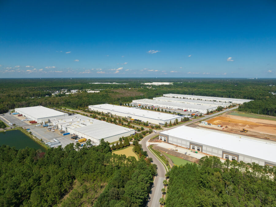 Aerial view of a large industrial park with warehouses and distribution centers surrounded by forest.