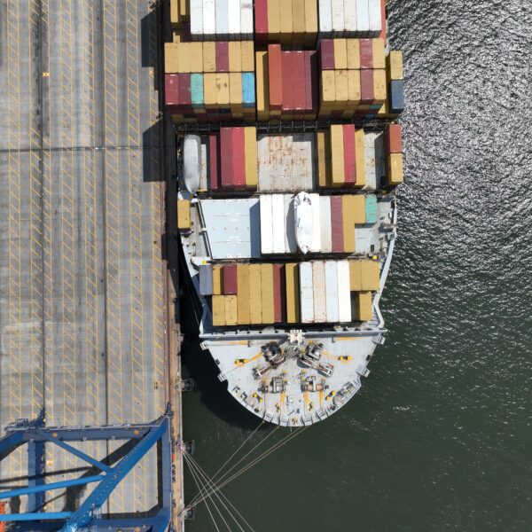 Aerial top-down view of a container ship docked at a port terminal.