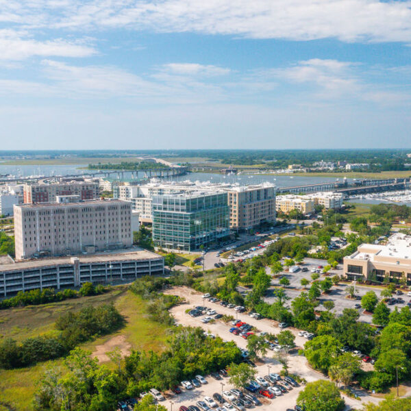 Aerial view of a waterfront commercial district with office buildings, marina, and parking lots.