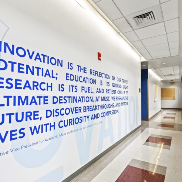 Hallway with a large blue wall quote about innovation and research at MUSC.