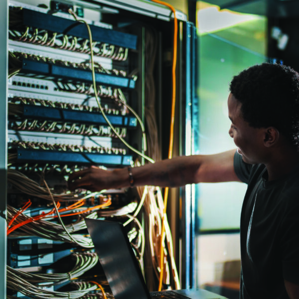 System administration, man is working in data center with laptop