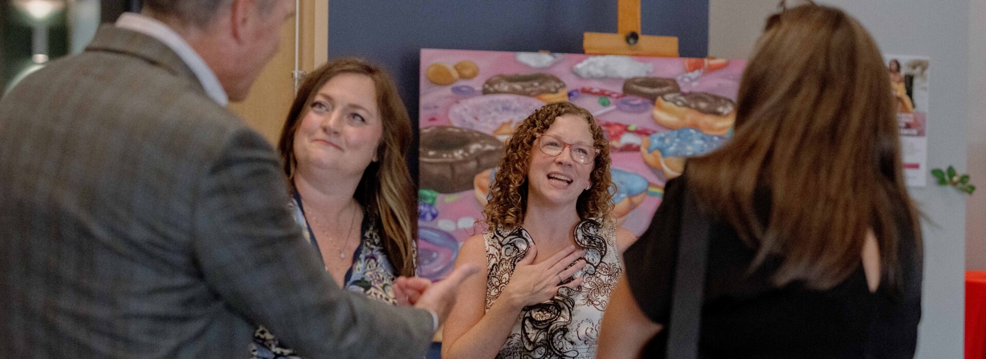 A group of coworkers smile and talk with each other.