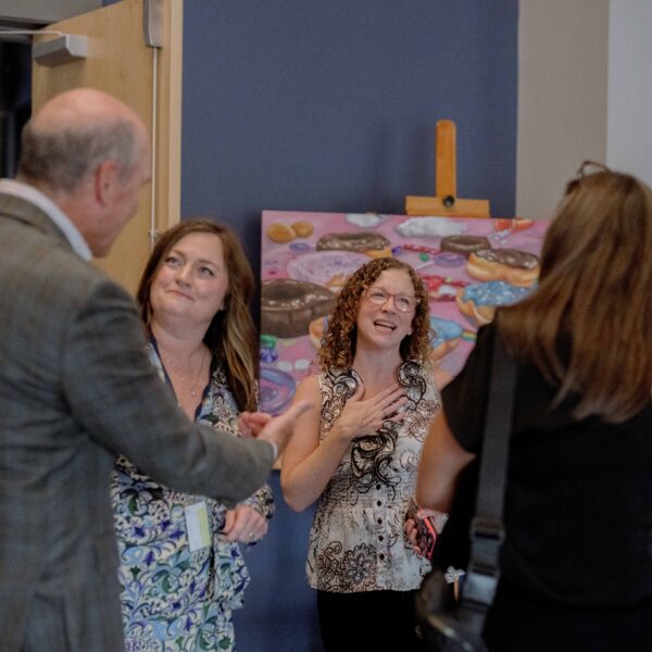 A group of coworkers smile and talk with each other.