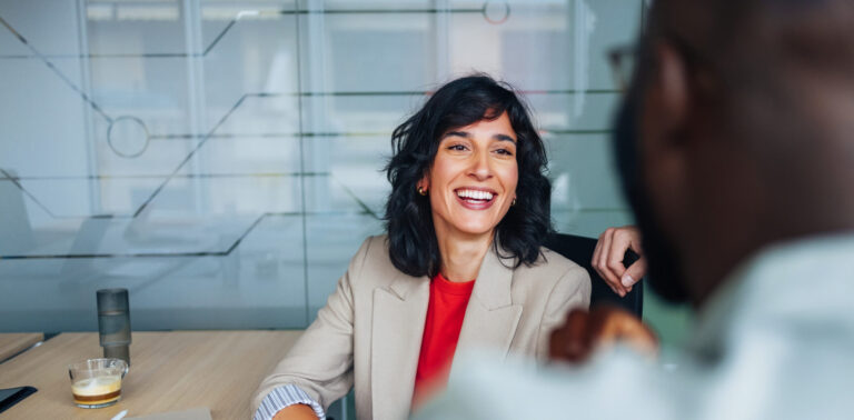 A business woman smiles at a colleague.