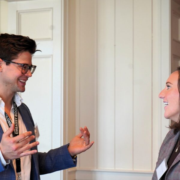 Two business people smile and converse with each other,