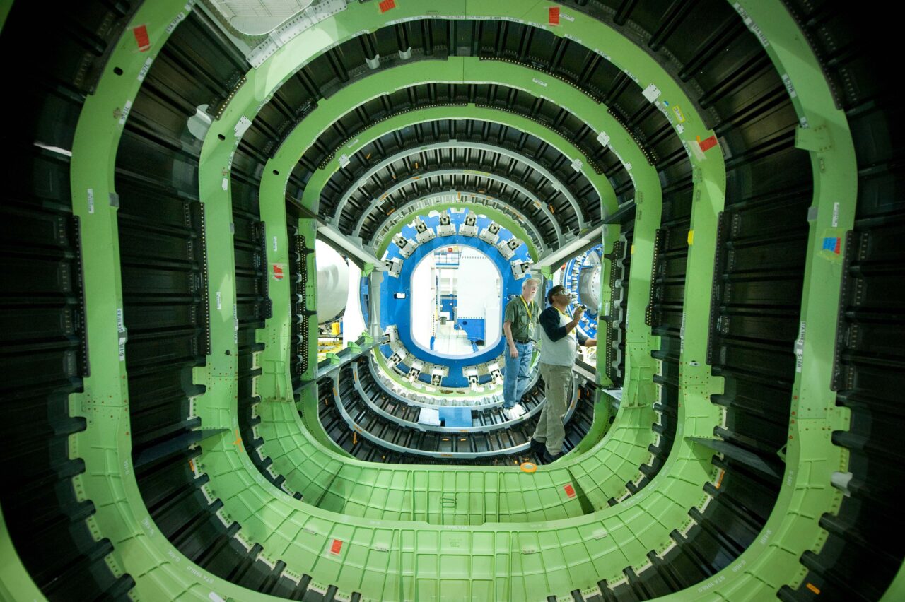 Two men work on the interior of an aerospace vehicle.