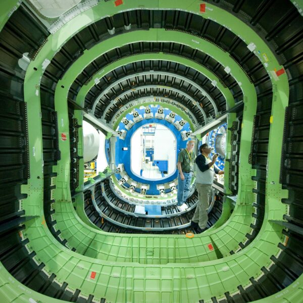 Two men work on the interior of an aerospace vehicle.